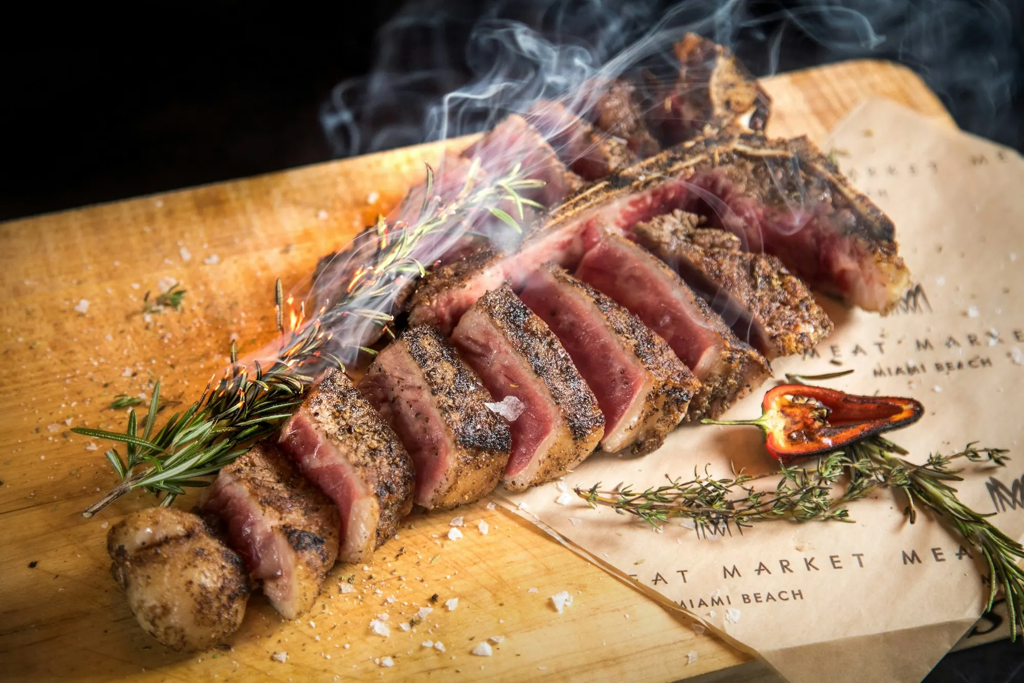 Sliced porterhouse with smoke on a Meat Market board